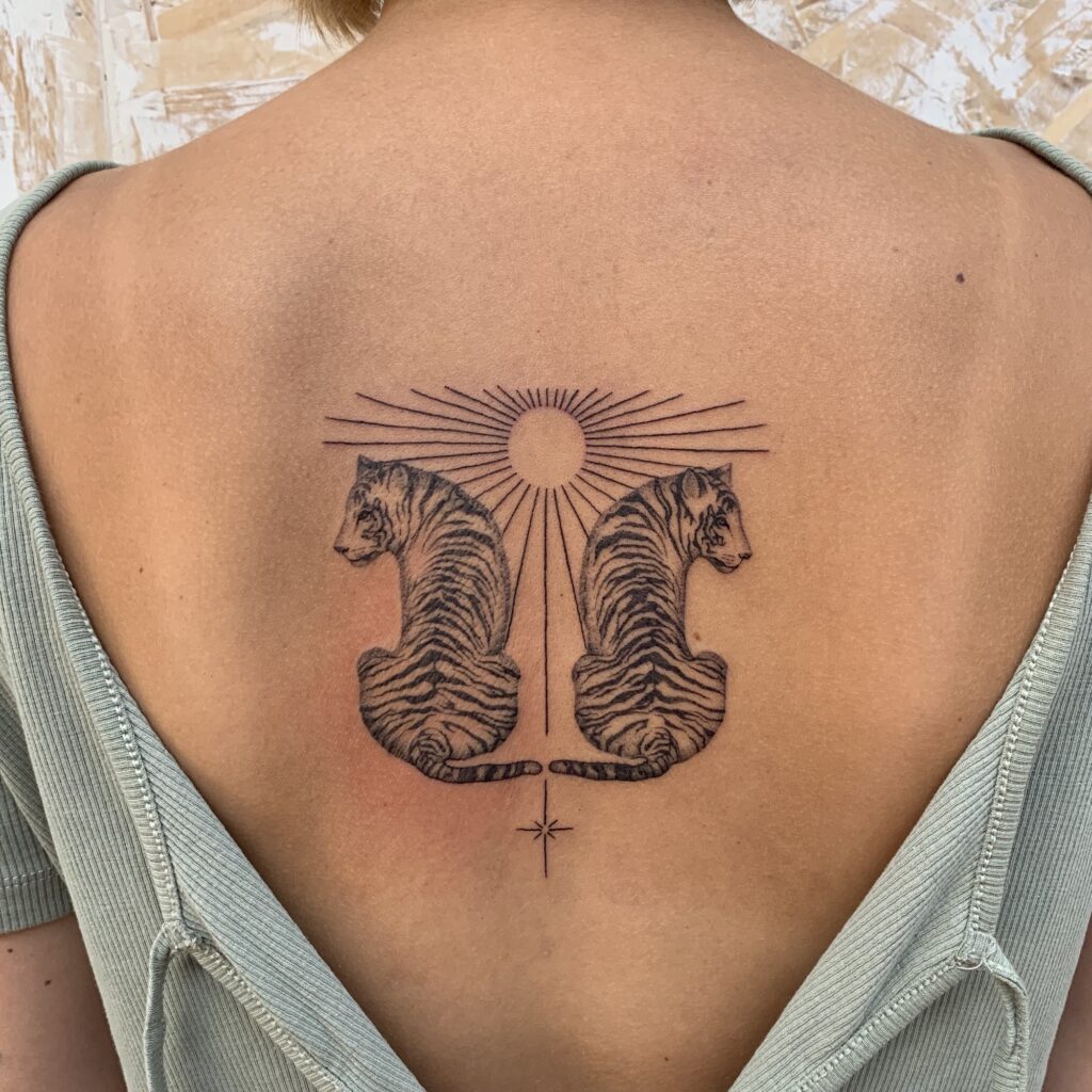 blackwork tigers and sun tattoo on woman back