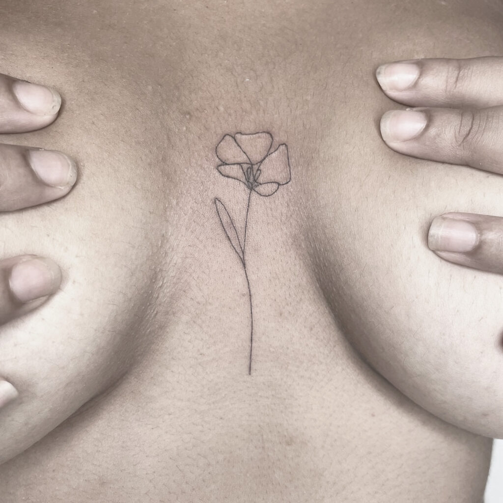 single line flower tattoo between boobs