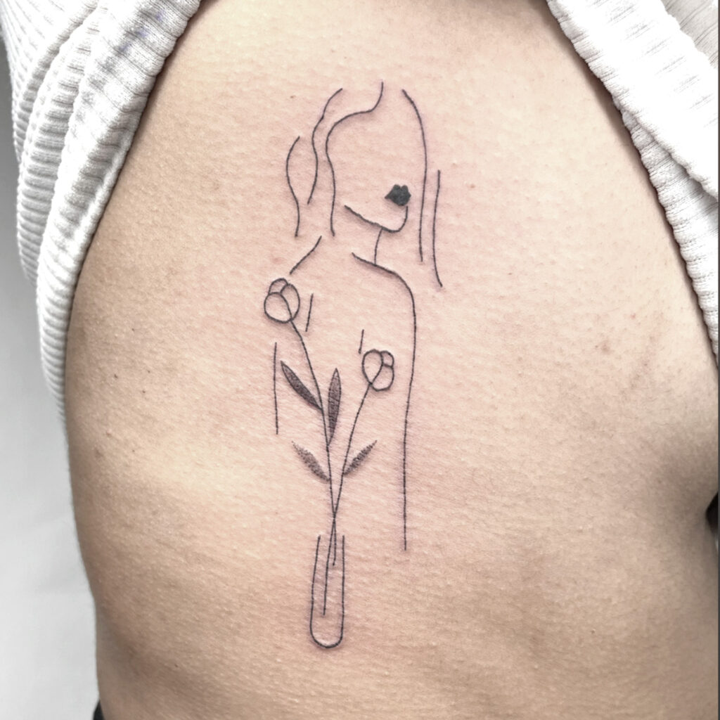 minimalist woman face and flower tattoo